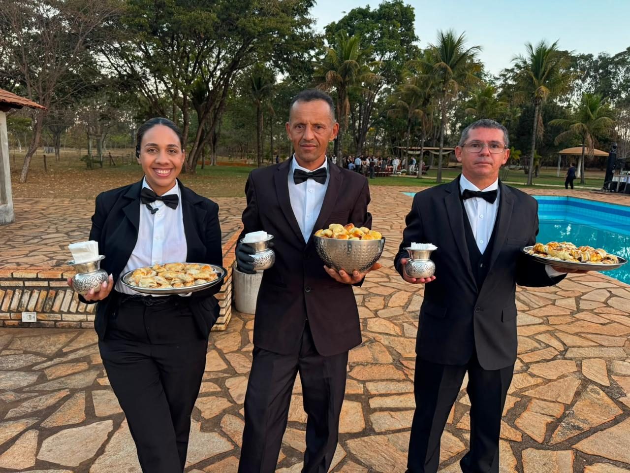 Equipe da Elementar servindo bandejas de salgados em um evento ao ar livre
